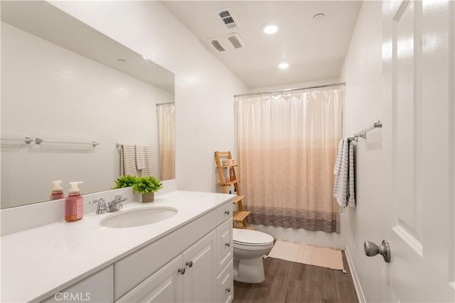 full bathroom with shower / tub combo with curtain, hardwood / wood-style floors, vanity, and toilet