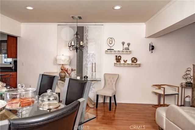 dining space with hardwood / wood-style flooring and crown molding