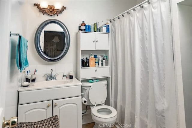 bathroom featuring vanity, decorative backsplash, and toilet