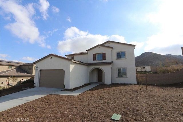 mediterranean / spanish house featuring a garage and a mountain view