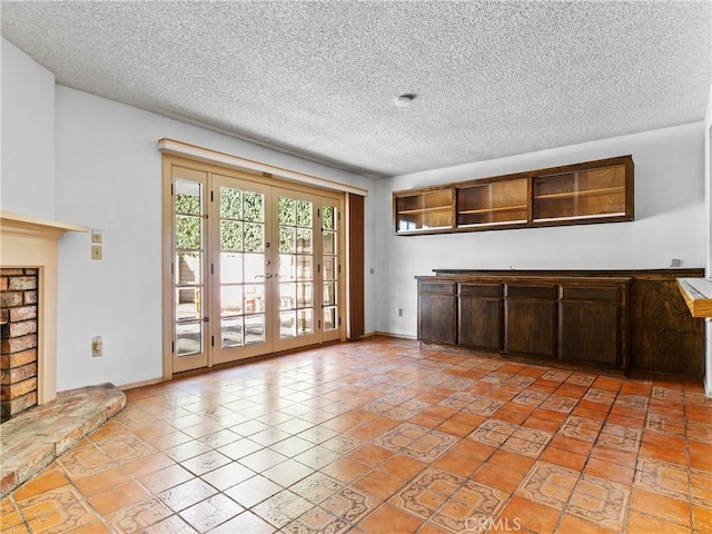 unfurnished living room featuring a textured ceiling and french doors