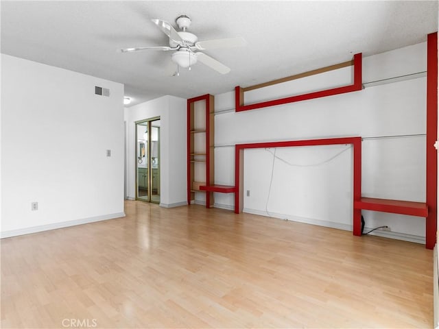 empty room with ceiling fan, light hardwood / wood-style flooring, and a textured ceiling