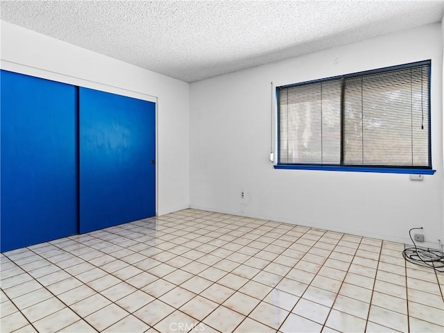 unfurnished room with a textured ceiling