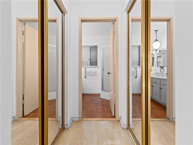 hallway with sink and light wood-type flooring