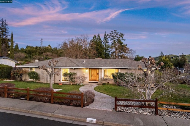 ranch-style home with a lawn