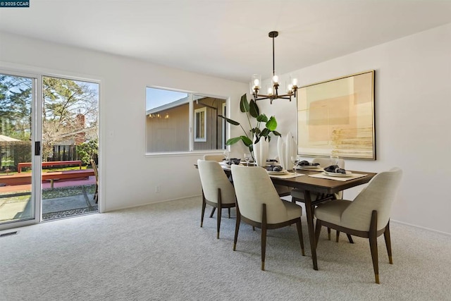 dining room featuring carpet floors and a chandelier