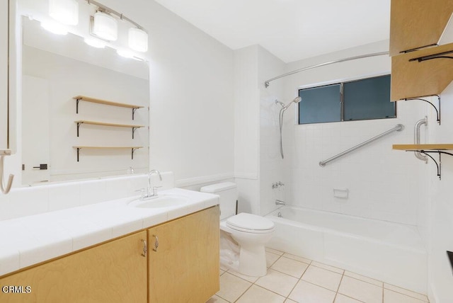 full bathroom with tile patterned flooring, tiled shower / bath, vanity, and toilet