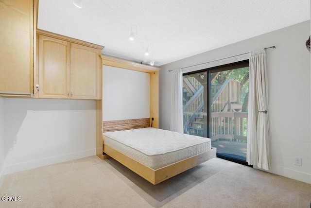 carpeted bedroom featuring access to outside and a textured ceiling