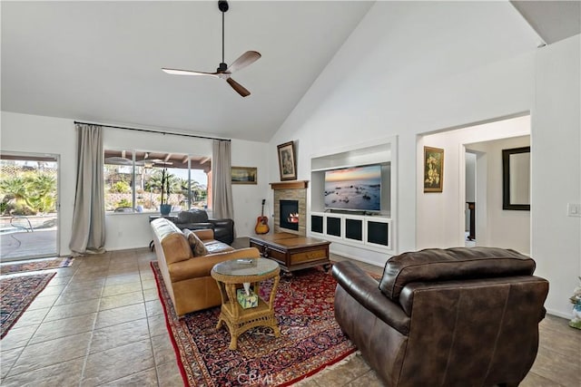 living area featuring built in features, high vaulted ceiling, a ceiling fan, and a stone fireplace