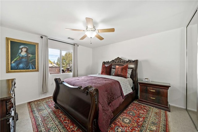 carpeted bedroom with a ceiling fan, visible vents, and baseboards