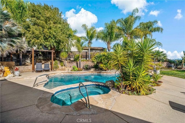 view of swimming pool featuring fence, a patio, and an in ground hot tub