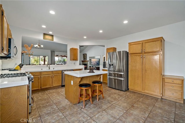 kitchen featuring appliances with stainless steel finishes, recessed lighting, a kitchen bar, and a center island