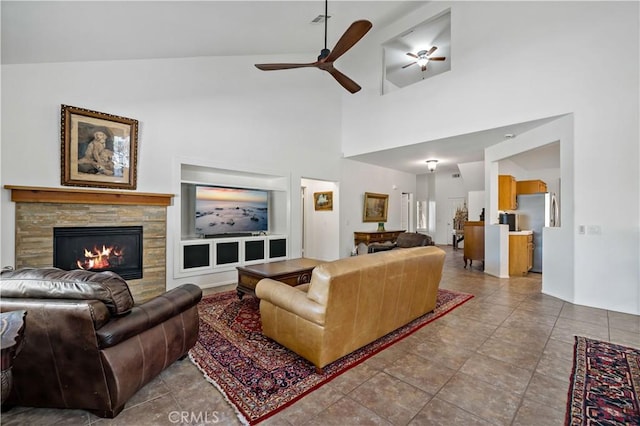 living room with a ceiling fan, tile patterned flooring, vaulted ceiling, and a fireplace