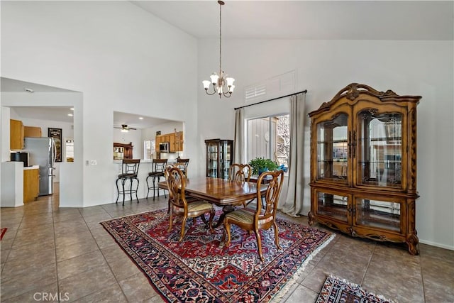 dining space featuring ceiling fan with notable chandelier, vaulted ceiling, and tile patterned floors