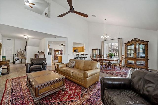 living room with light tile patterned floors, visible vents, high vaulted ceiling, and ceiling fan with notable chandelier