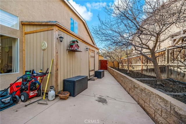 view of home's exterior with a patio area and fence