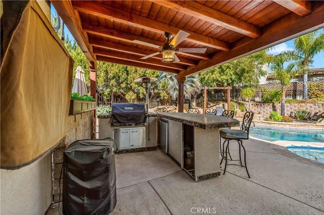 view of patio with an outdoor kitchen, a fenced in pool, a fenced backyard, a grill, and outdoor wet bar