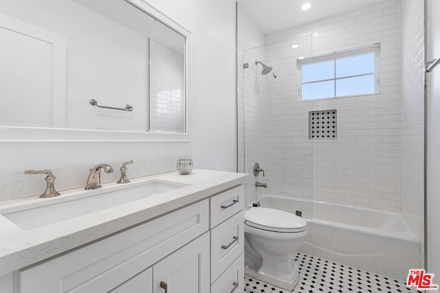 full bathroom featuring vanity, tile patterned floors, toilet, and tiled shower / bath