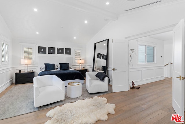 bedroom with ornamental molding, vaulted ceiling with beams, and light wood-type flooring