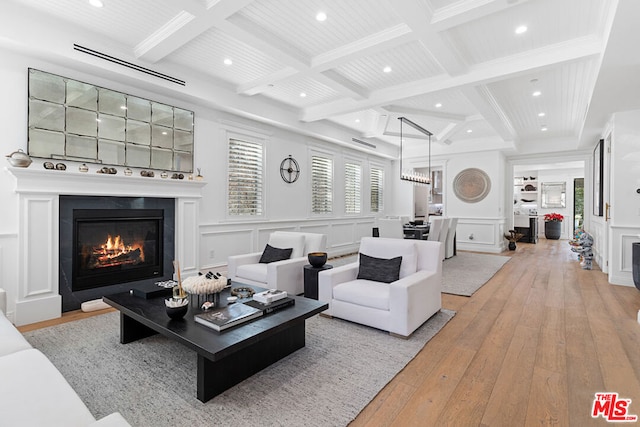 living room featuring coffered ceiling, light wood-type flooring, and beam ceiling