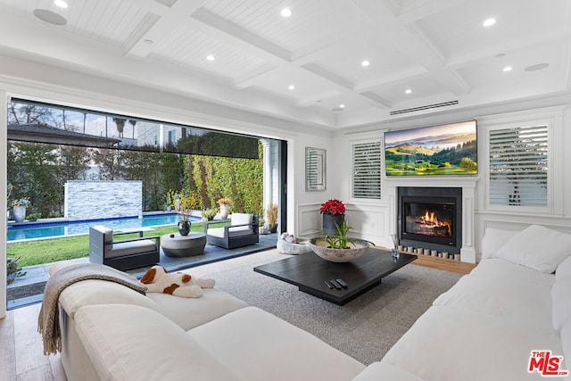 living room with coffered ceiling, hardwood / wood-style flooring, and beam ceiling