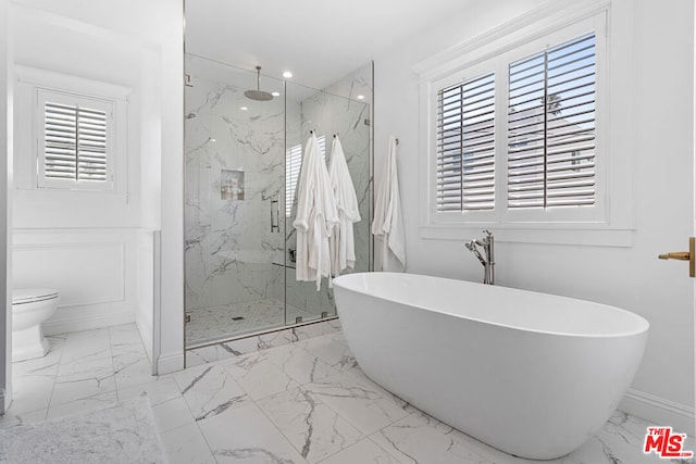 bathroom featuring plus walk in shower, plenty of natural light, and toilet