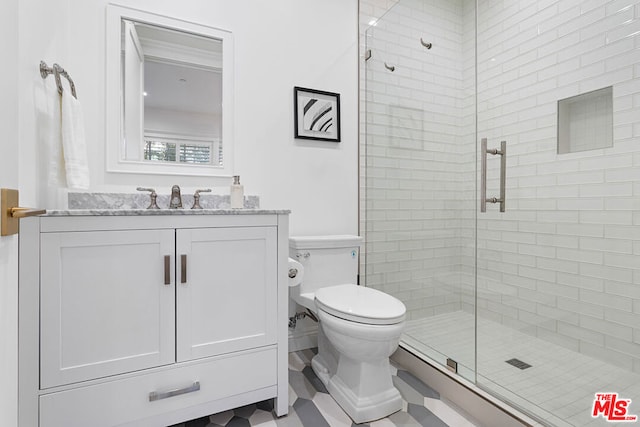 bathroom featuring vanity, an enclosed shower, and toilet