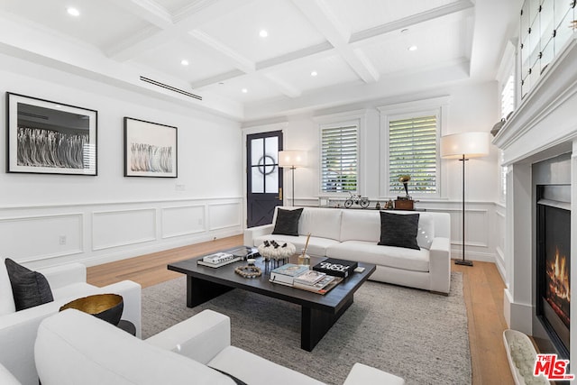 living room featuring coffered ceiling, beamed ceiling, and light wood-type flooring