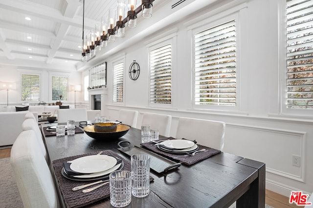 dining area with beamed ceiling, coffered ceiling, and hardwood / wood-style floors