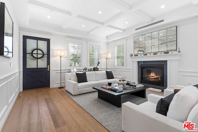 living room featuring beamed ceiling, coffered ceiling, and light wood-type flooring