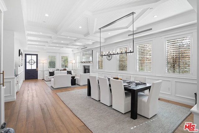 dining room with coffered ceiling, beam ceiling, and light hardwood / wood-style floors