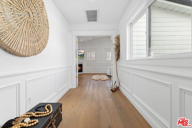 hall featuring lofted ceiling and light wood-type flooring