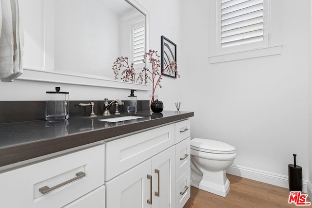 bathroom with vanity, hardwood / wood-style floors, and toilet