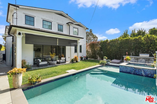 rear view of house with a swimming pool with hot tub and a yard