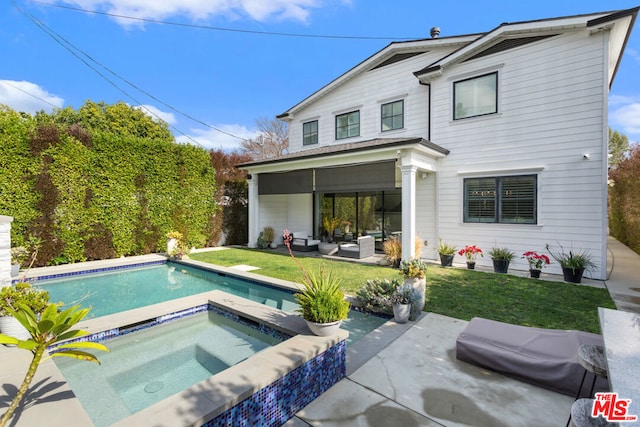 back of property with a patio, outdoor lounge area, a pool with hot tub, and a lawn