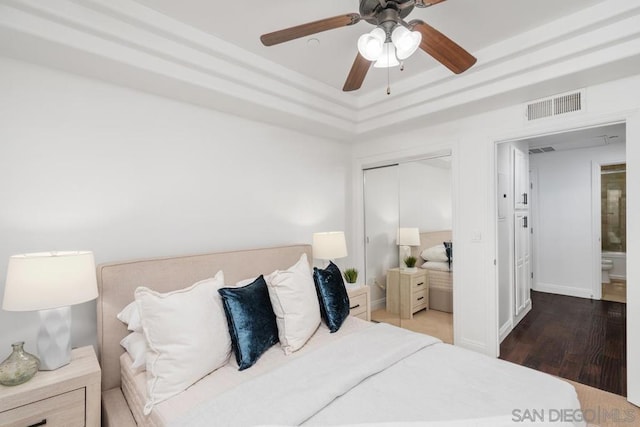 bedroom with ceiling fan, dark hardwood / wood-style floors, and a closet