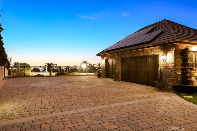 property exterior at dusk with a garage and solar panels