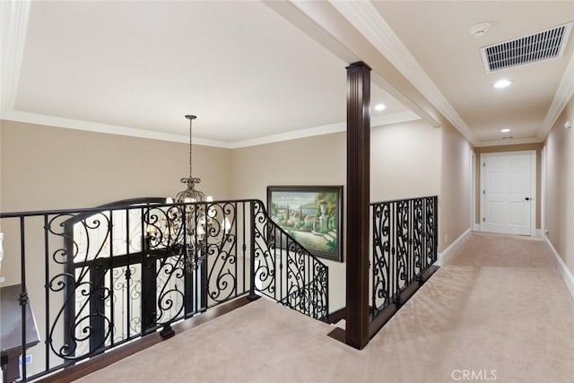 hall with crown molding, carpet flooring, and an inviting chandelier