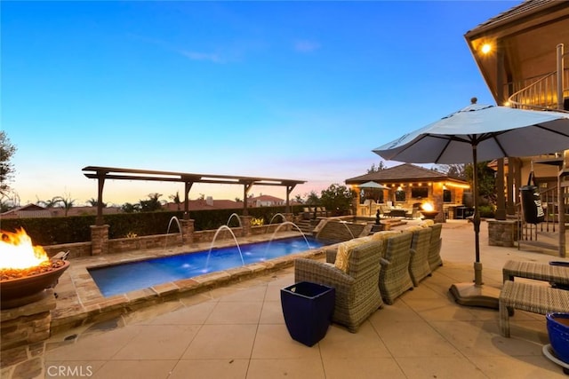 pool at dusk with a patio and an outdoor living space with a fire pit