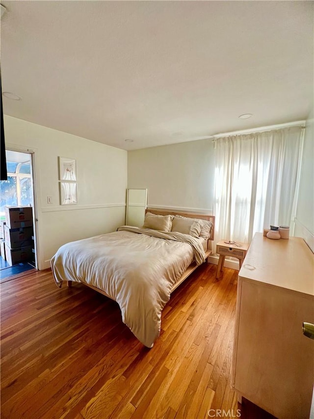 bedroom with access to outside and light wood-type flooring