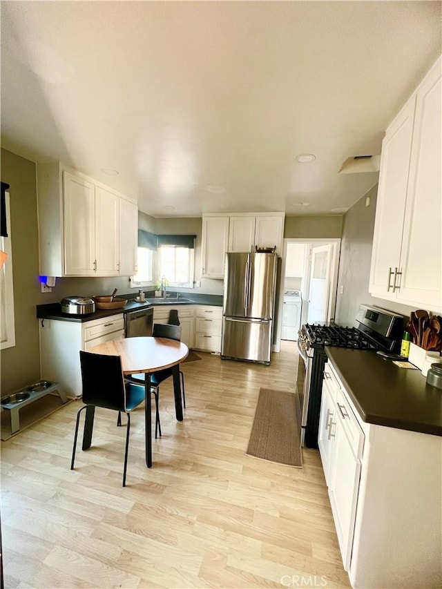 kitchen featuring white cabinetry, sink, light hardwood / wood-style flooring, and appliances with stainless steel finishes