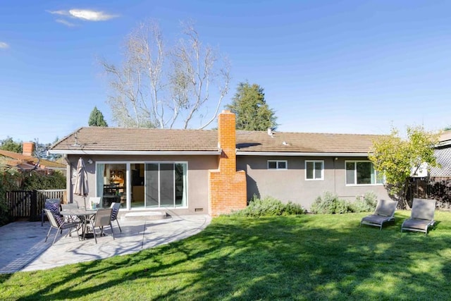 back of house featuring a patio and a yard