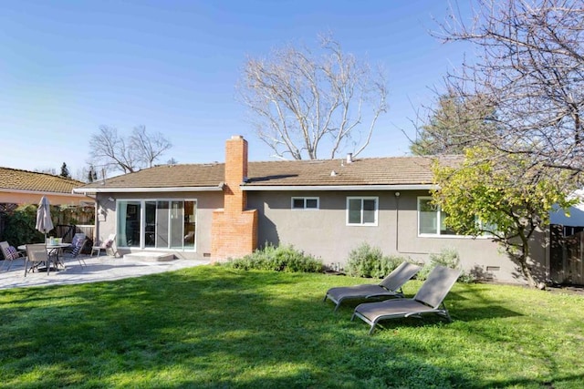 rear view of house with a patio area and a lawn