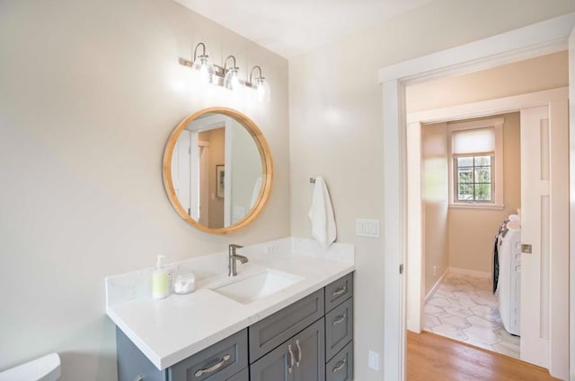 bathroom featuring hardwood / wood-style flooring, vanity, and washer and clothes dryer