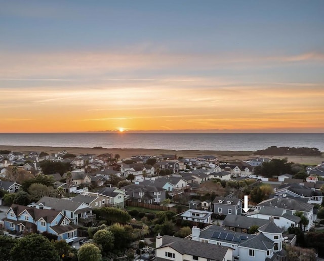 aerial view at dusk featuring a water view