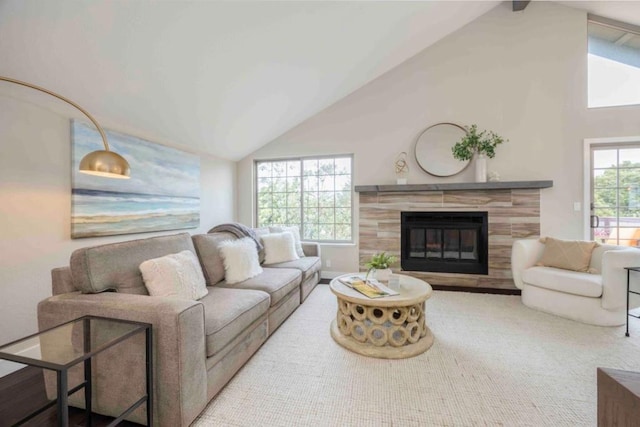 living room with a fireplace and high vaulted ceiling