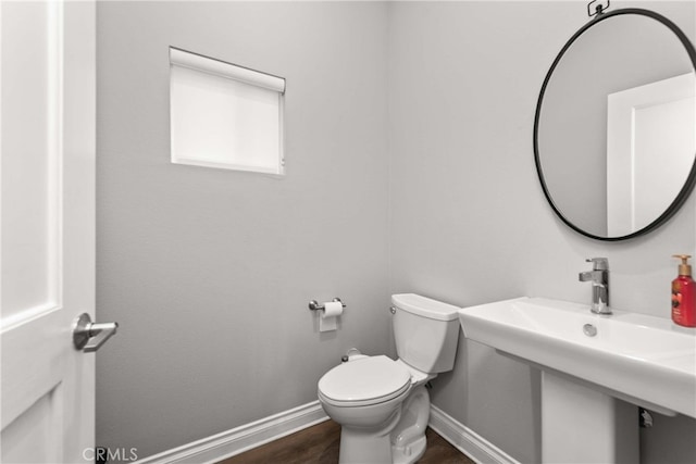 bathroom with hardwood / wood-style flooring and toilet