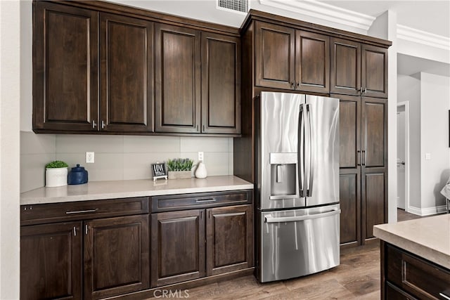 kitchen with stainless steel refrigerator with ice dispenser, tasteful backsplash, dark hardwood / wood-style flooring, and dark brown cabinets