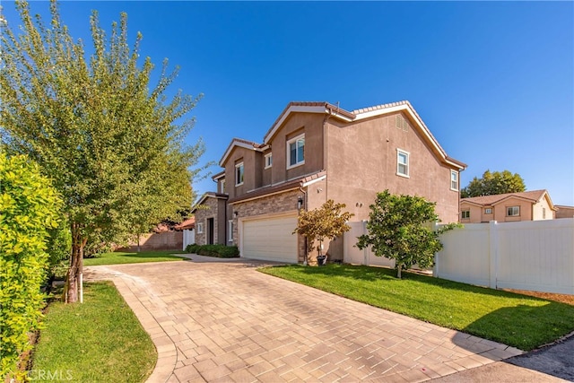 mediterranean / spanish home featuring a garage and a front lawn