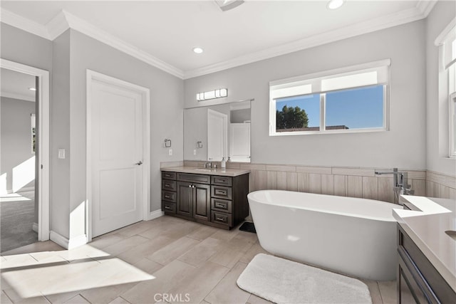 bathroom featuring vanity, a wealth of natural light, crown molding, and a tub to relax in